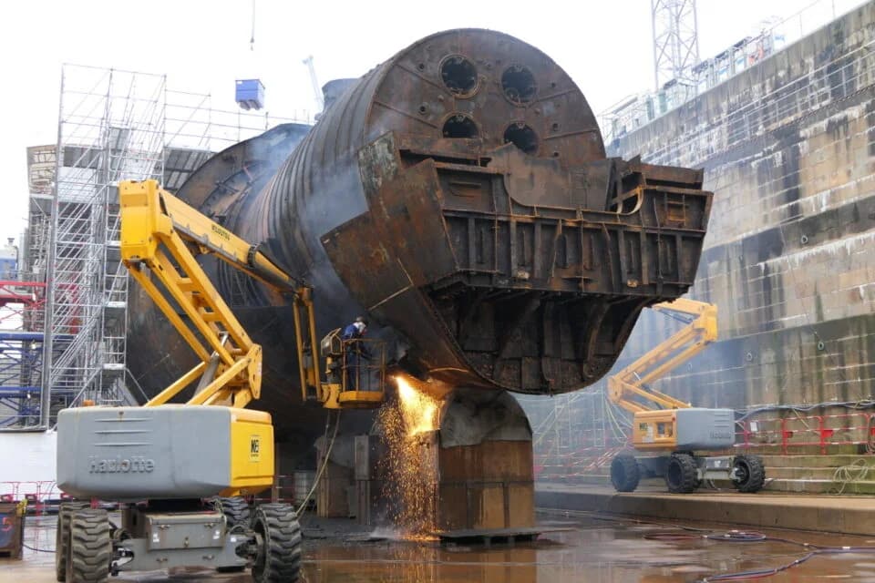 Navire et structures portuaires en cours de découpe sur un chantier naval